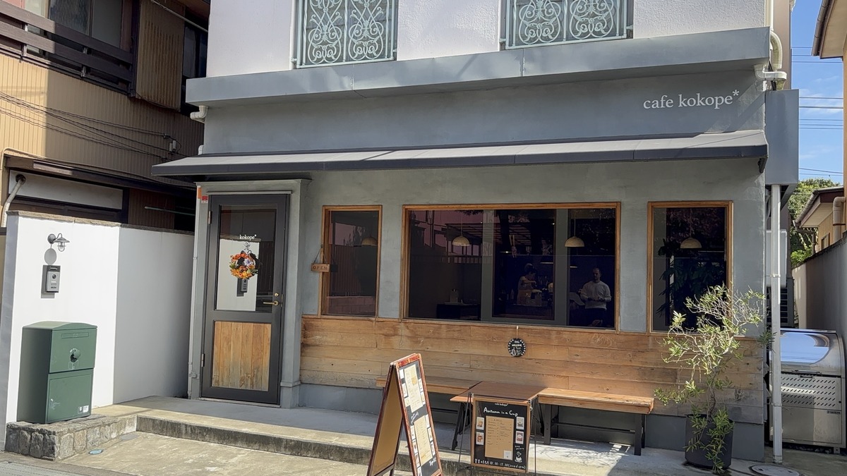 鎌倉のカフェココペのグレーのひさしと木枠の窓がある外観