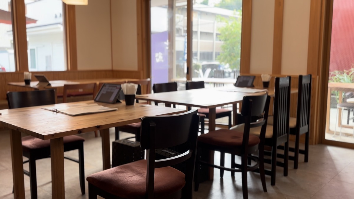 木のテーブルと大きな窓が並ぶ日本料理 古古の店内