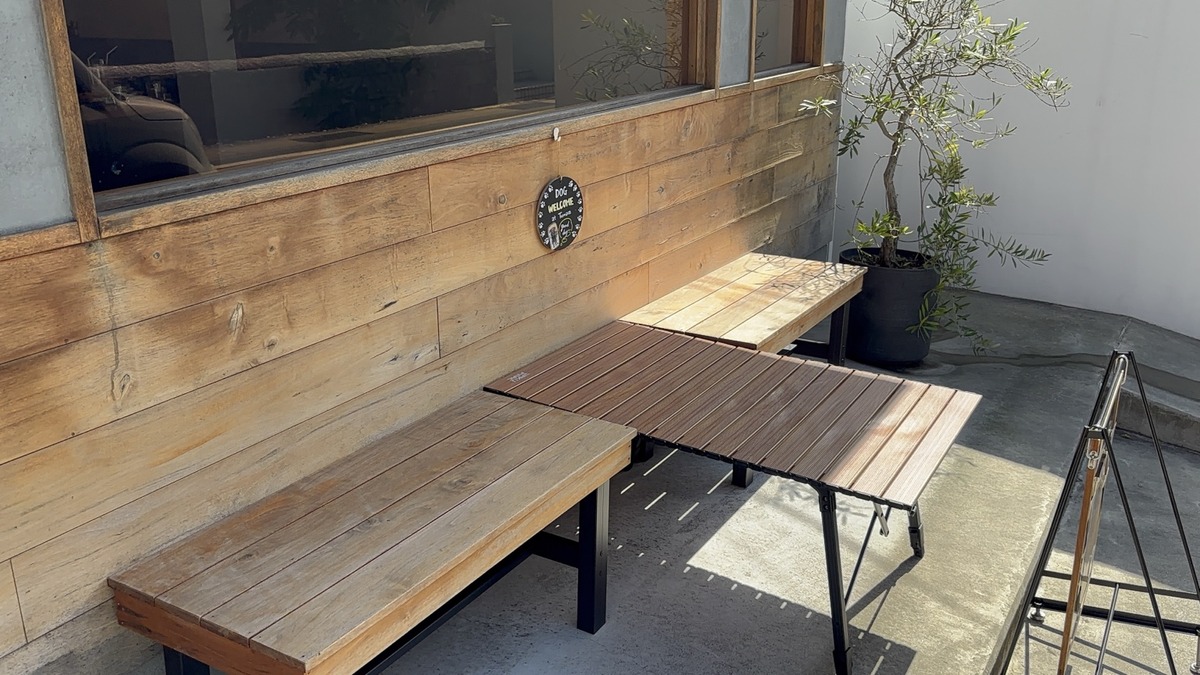 カフェココペの店先にある木のベンチと植栽
